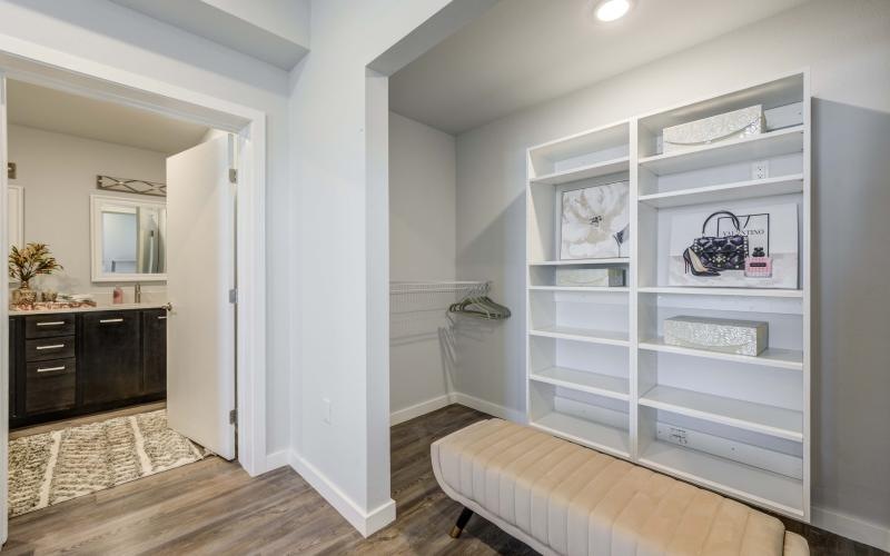 a room with a bed and a shelf with books