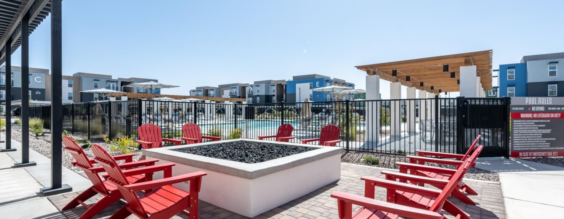 a patio with red chairs and a view of a city